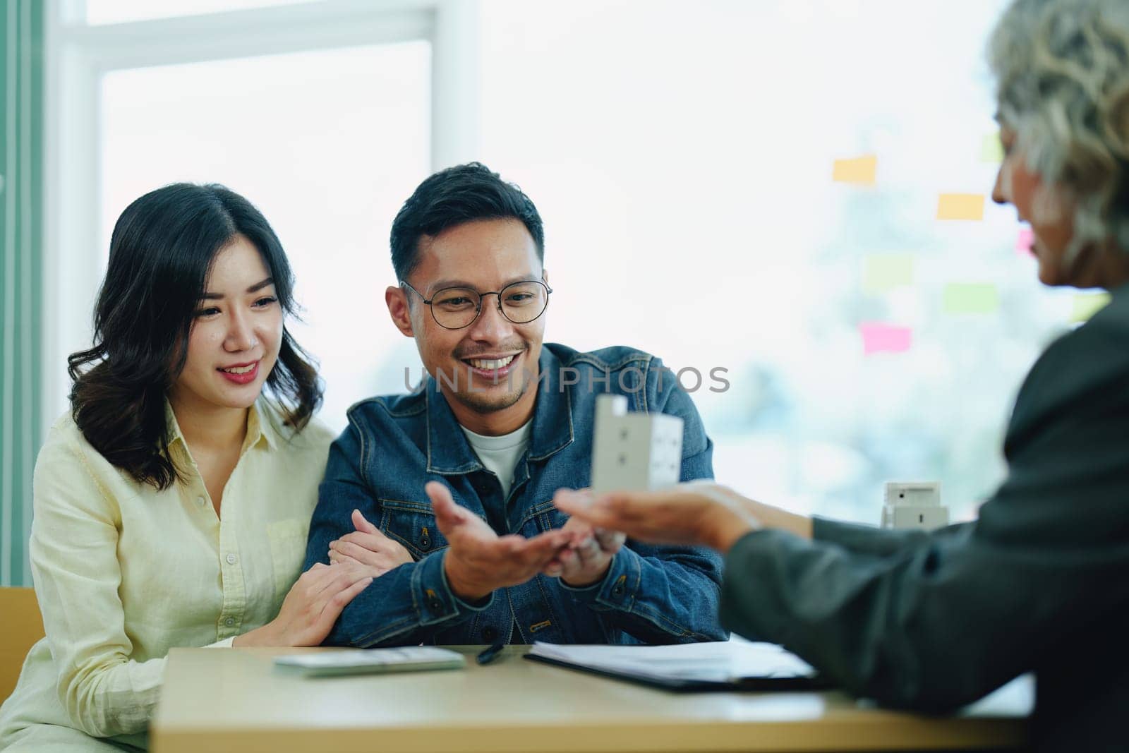 Guarantee Insurance Sign a contract, couple a smiling couple is signing a contract to invest in real estate with the Mortgage officer with the bank by Manastrong