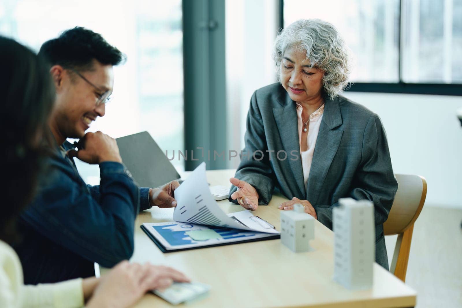 Guarantee Insurance Sign a contract, couple a smiling couple is signing a contract to invest in real estate with the Mortgage officer with the bank by Manastrong