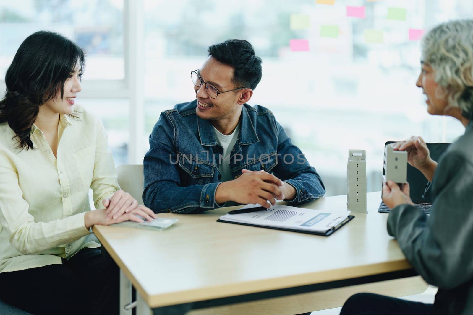 Guarantee Insurance Sign a contract, couple a smiling couple is signing a contract to invest in real estate with the Mortgage officer with the bank by Manastrong