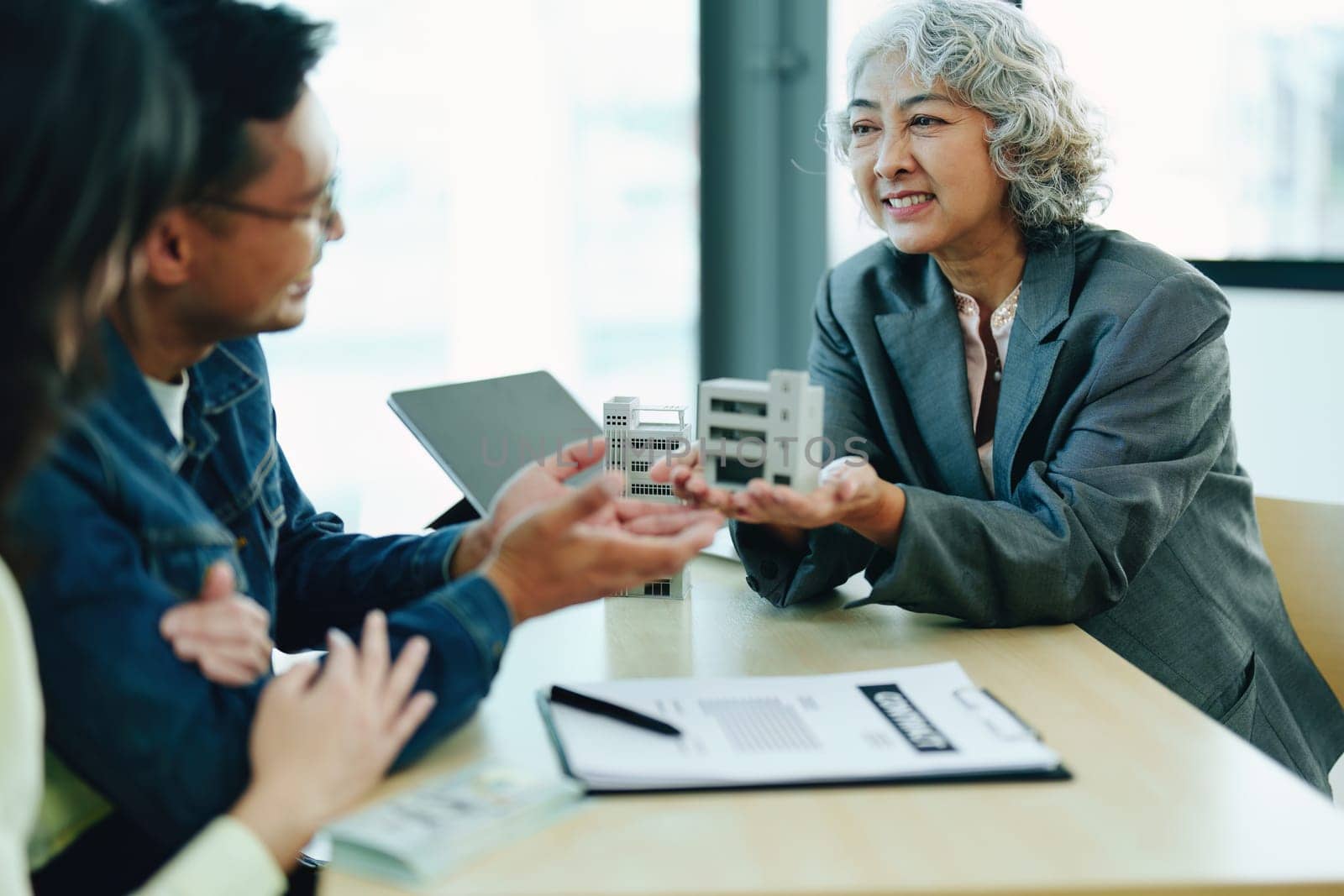 Guarantee Insurance Sign a contract, couple a smiling couple is signing a contract to invest in real estate with the Mortgage officer with the bank by Manastrong