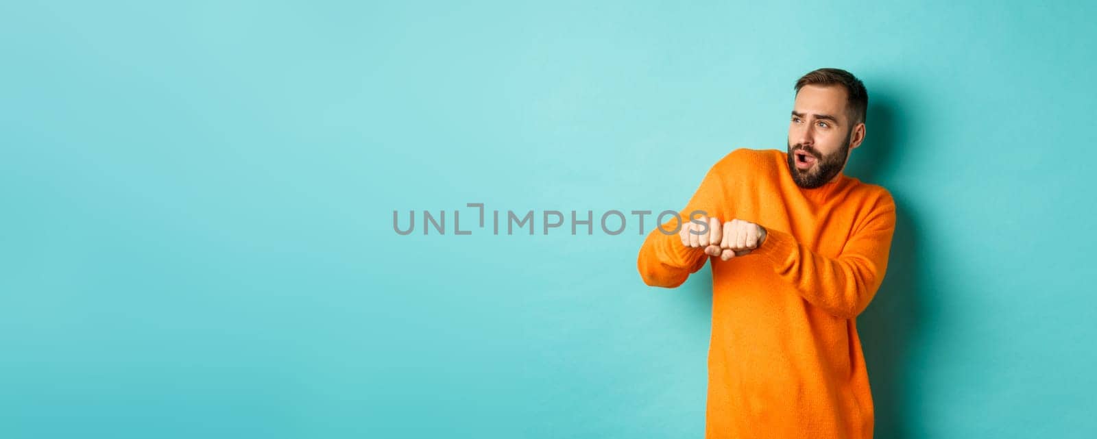 Happy young man do champion dance, celebrating victory or success, light blue background.