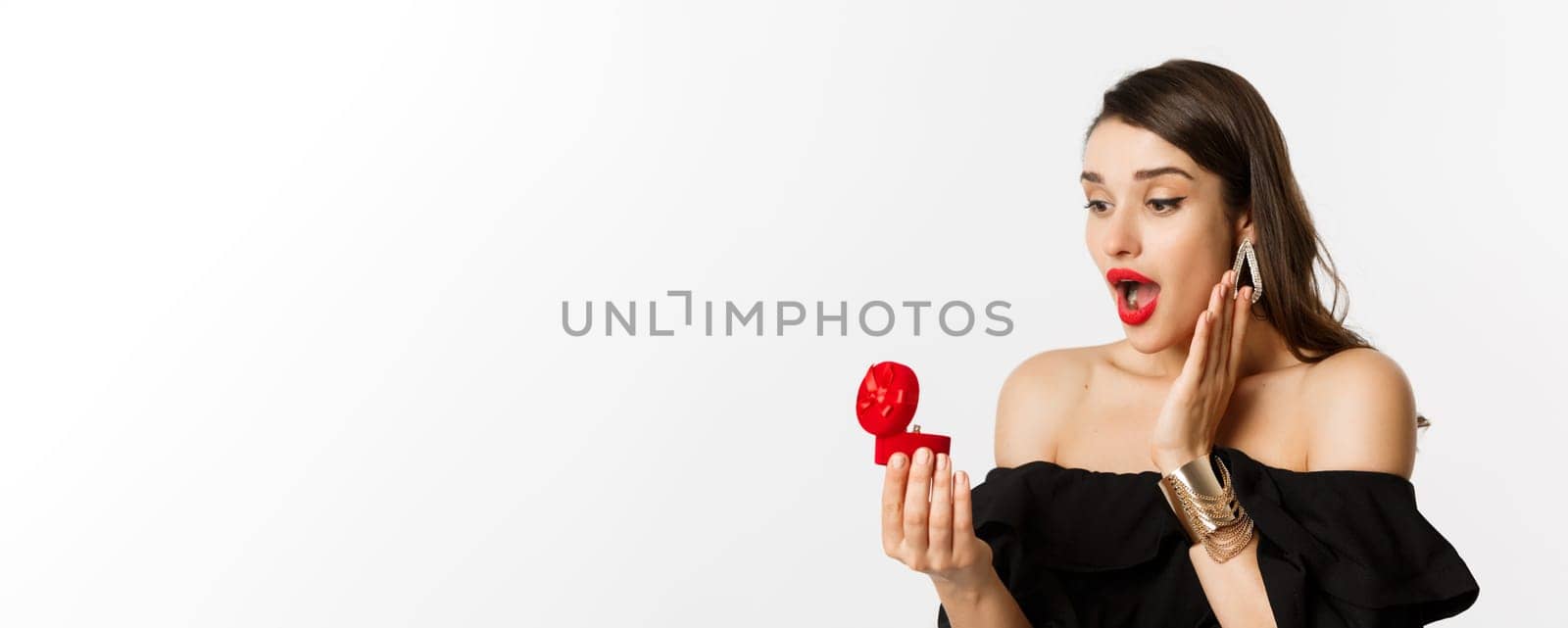 Close-up of surprised woman open box with engagement ring, looking amazed, receiving marriage proposal, girlfriend getting married by Benzoix