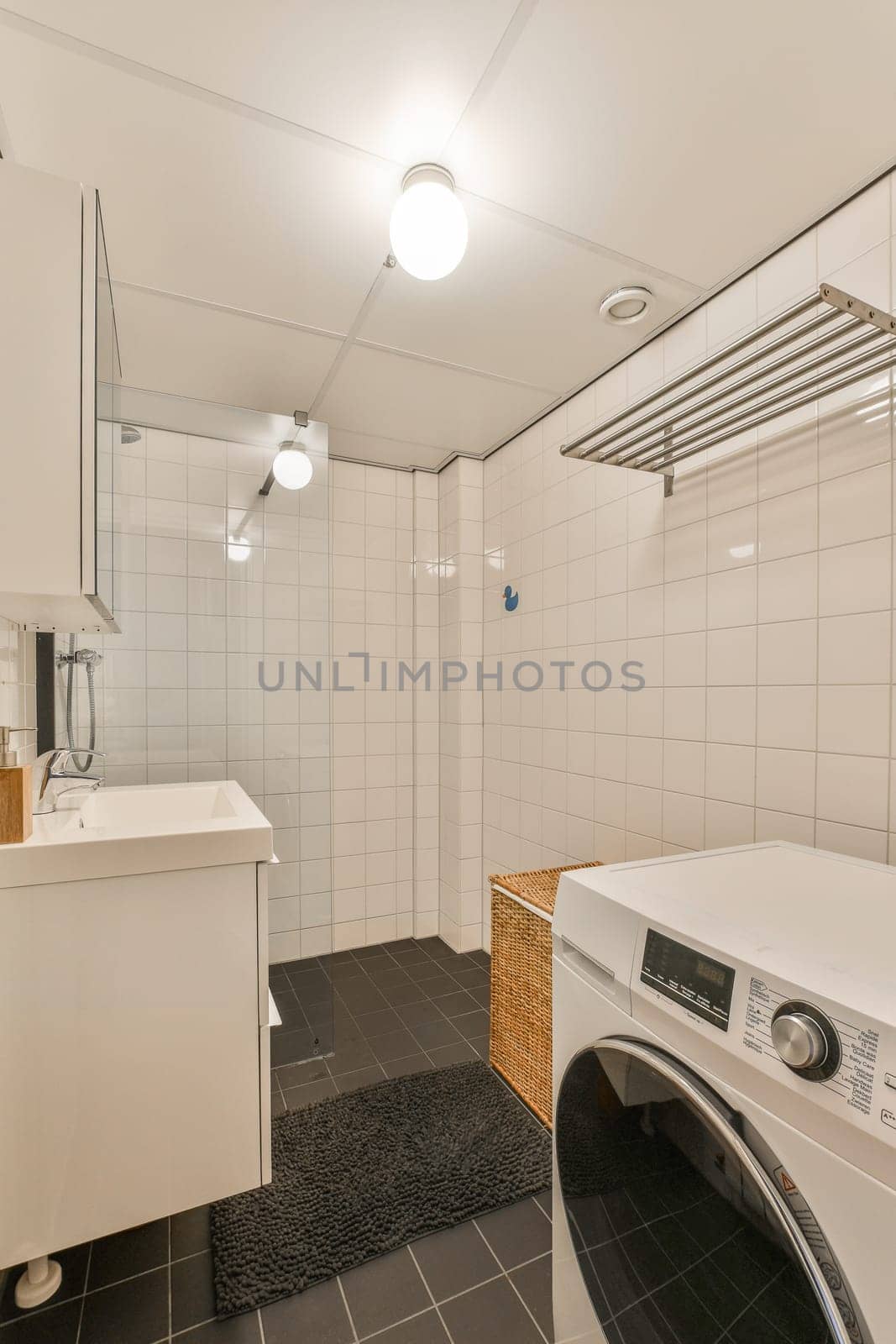 a laundry room with a washing machine and a sink by casamedia