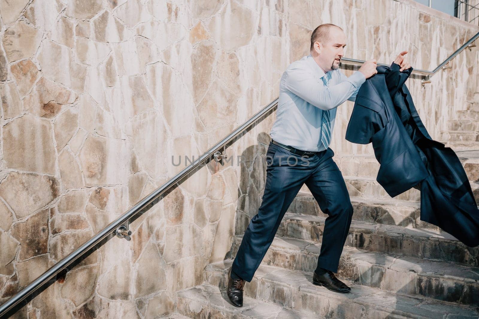 Portrait of a senior professional man in a suit with various problems. A middle-aged businessman with a briefcase descends the stairs.
