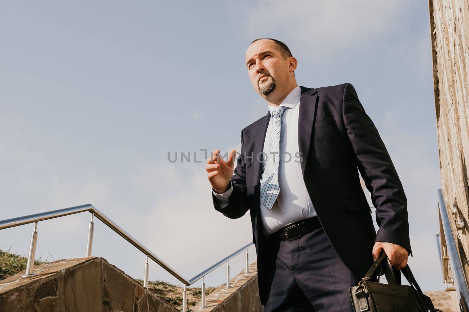 Business executive with briefcase going down the stairs.