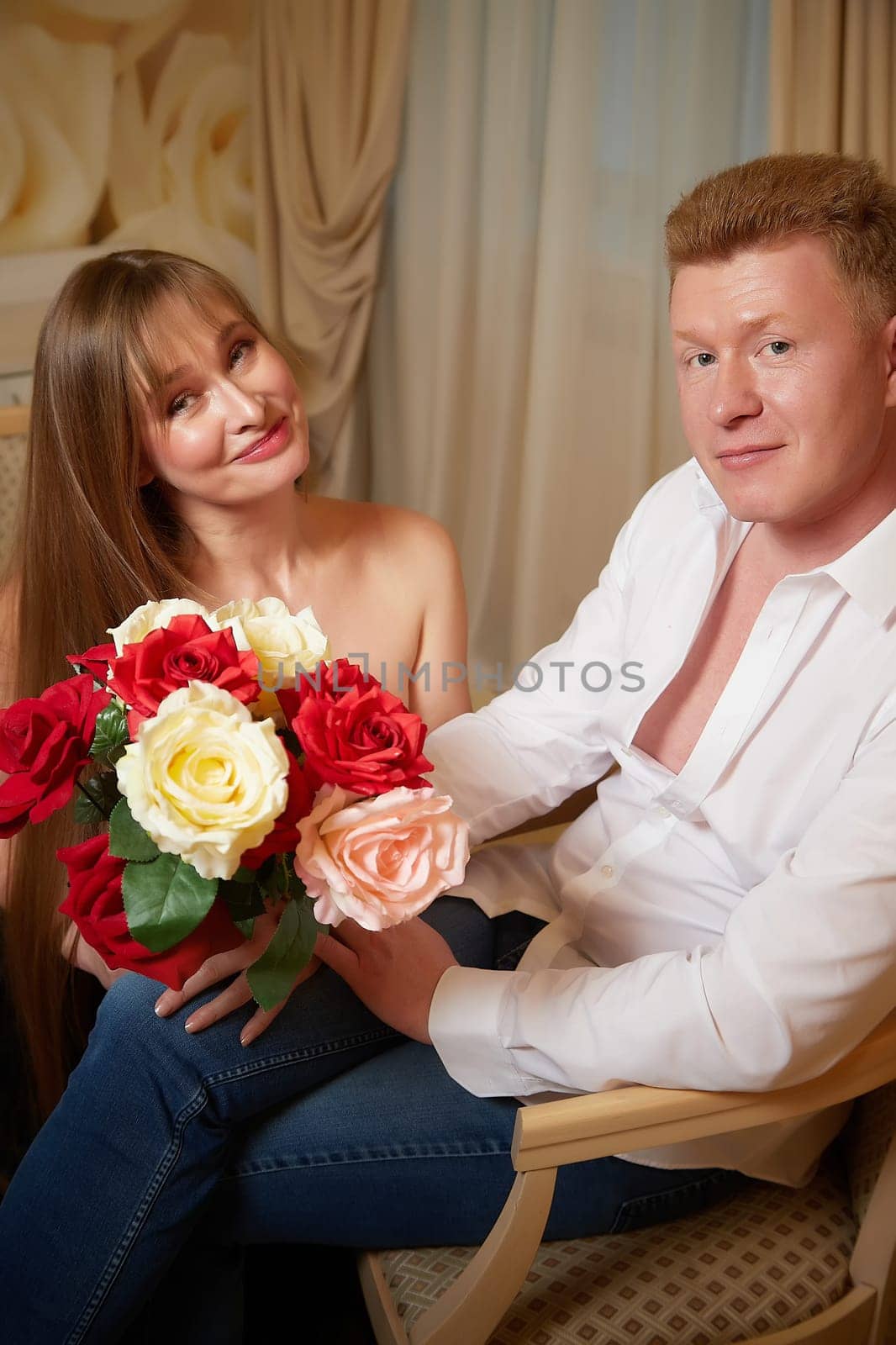 An adult couple of newlyweds in beautiful dress in a hotel room after the wedding. A guy and a girl, a man and a woman in a beautiful room. The concept of love and care by keleny