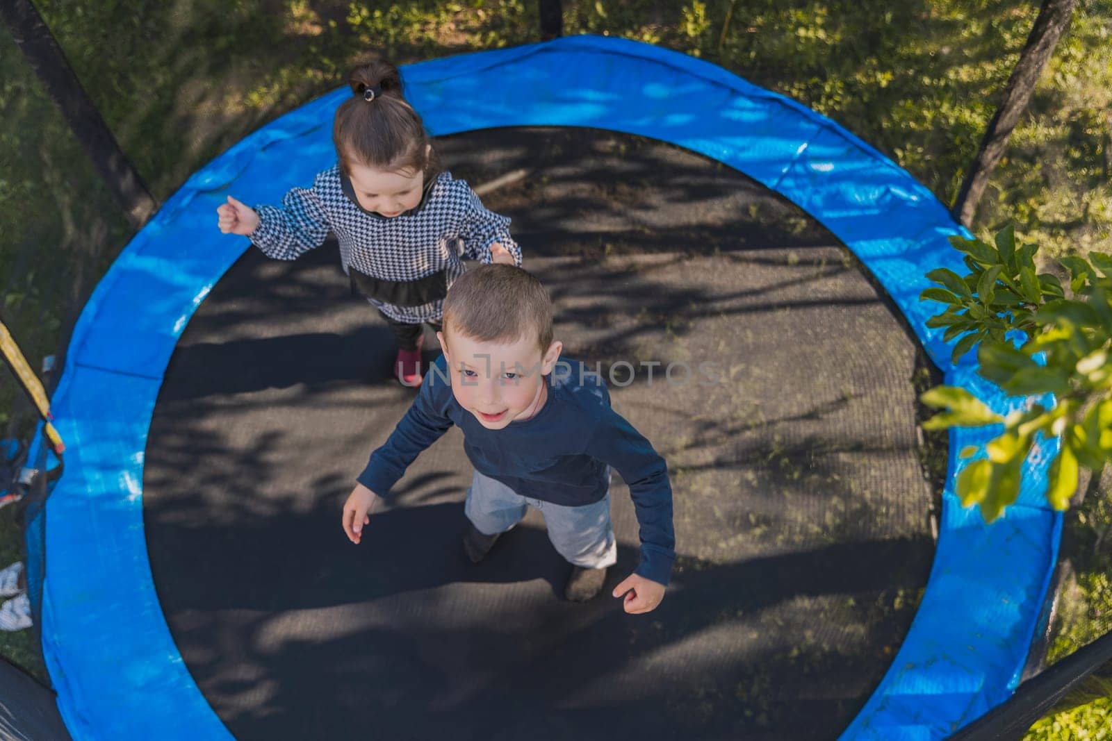 children jumping on a trampoline top view