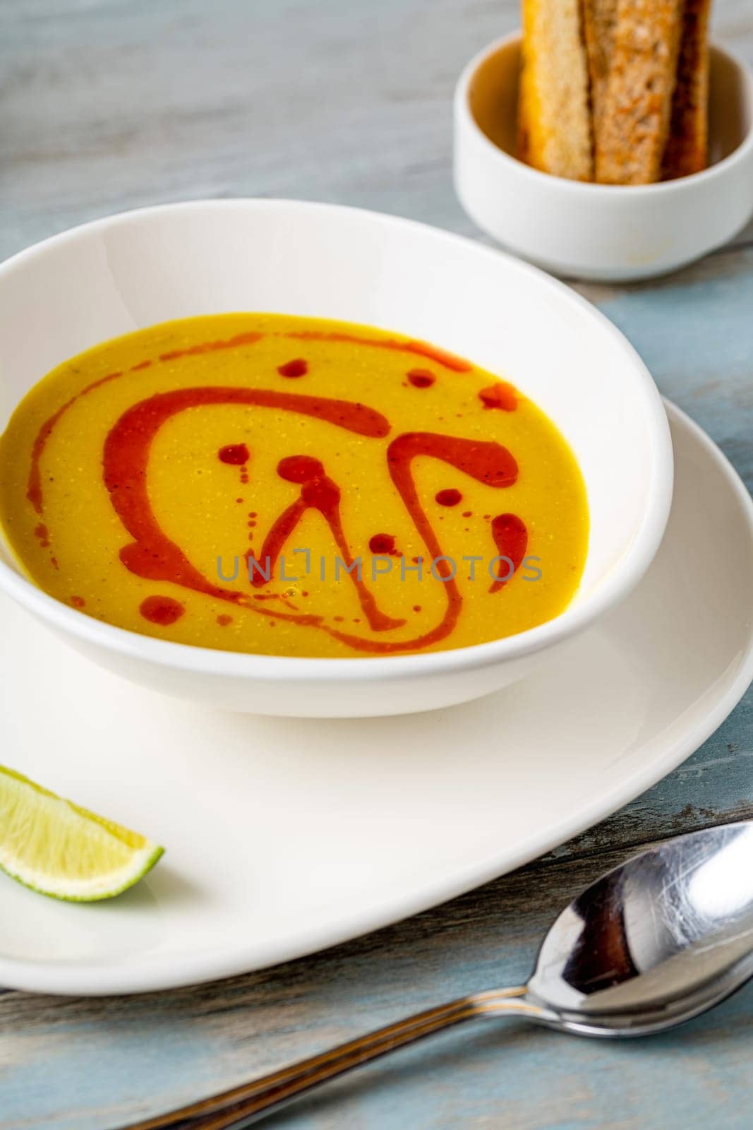 Strained lentil soup on a white porcelain plate by Sonat