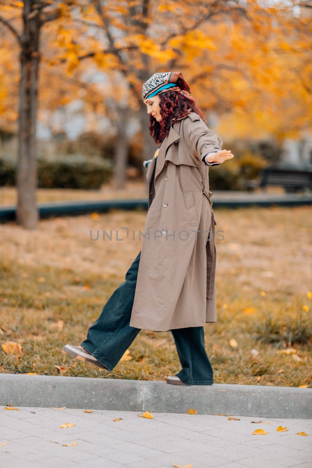 A woman walks outdoors in autumn, enjoys the autumn weather