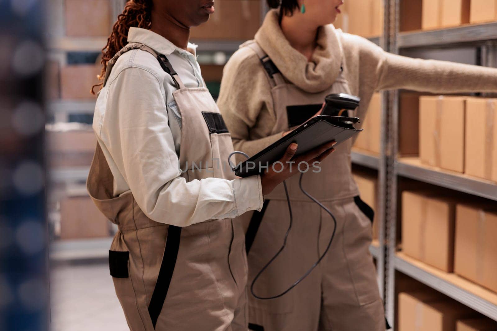 Retail warehouse managers scanning cardboard box on shelf and making store products overview. E commerce shop delivery service employees using barcode scanner on parcels before transportation
