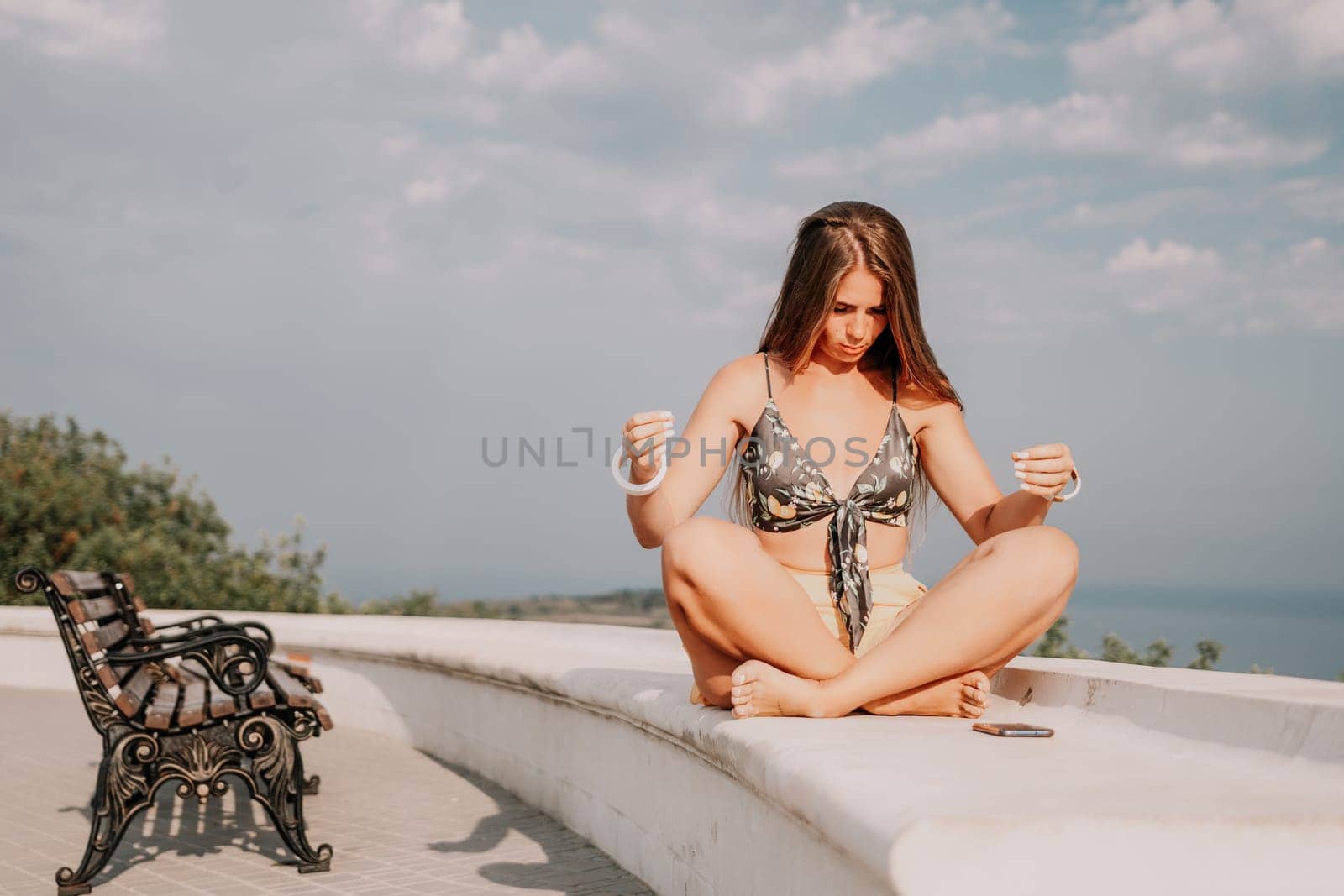 Woman park yoga. Side view of free calm bliss satisfied woman with long hair standing in morning park with yoga position against of sky by the sea. Healthy lifestyle outdoors in park, fitness concept