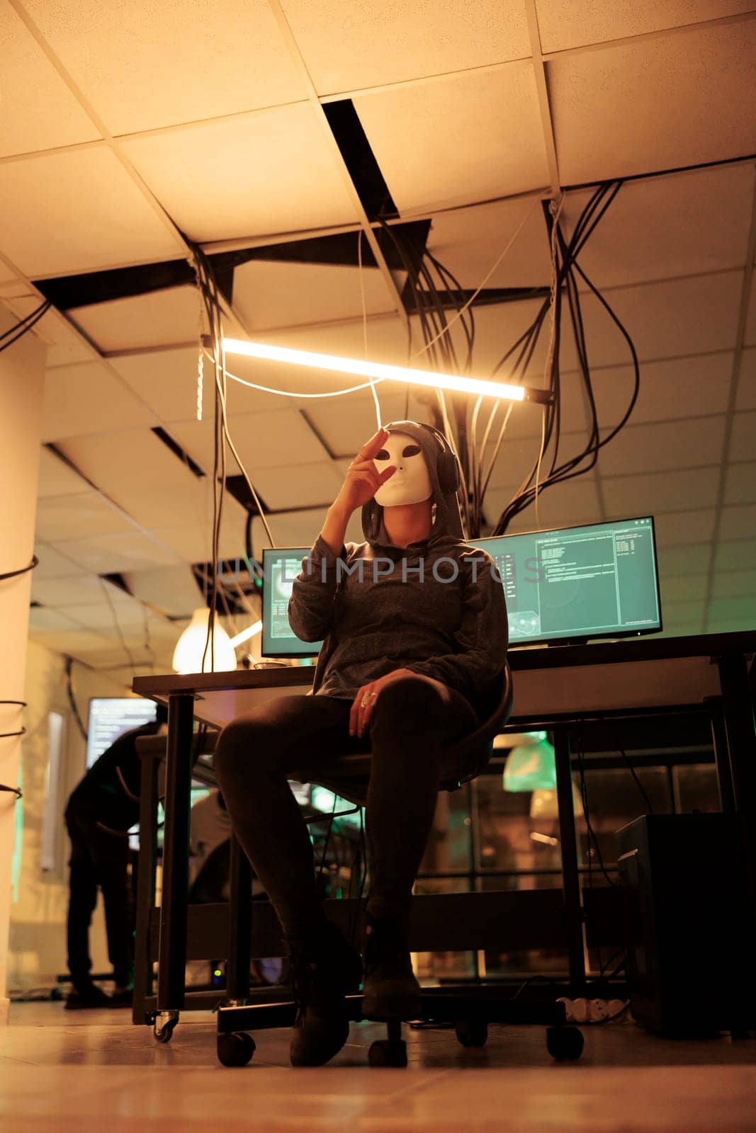 Spy with anonymous mask analyzing hologram to break into system by DCStudio