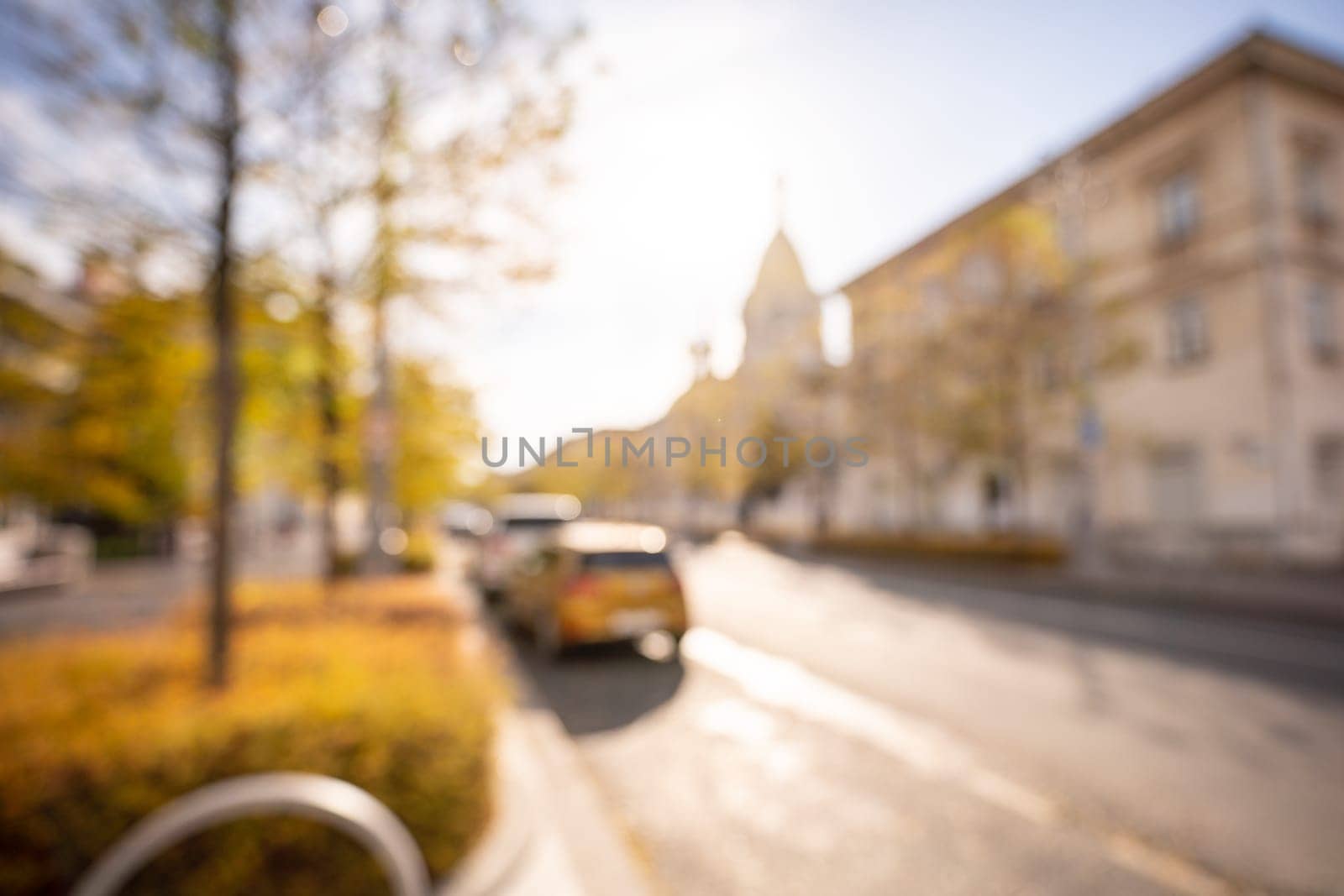 Autumn season bokeh background. Abstract city blur along the road with cars