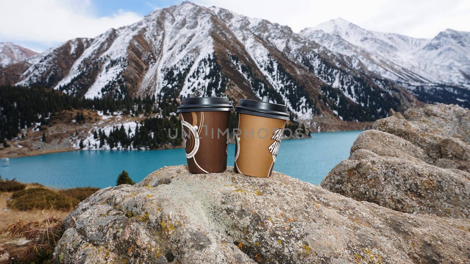 Paper cups on the background of a mountain lake by Passcal