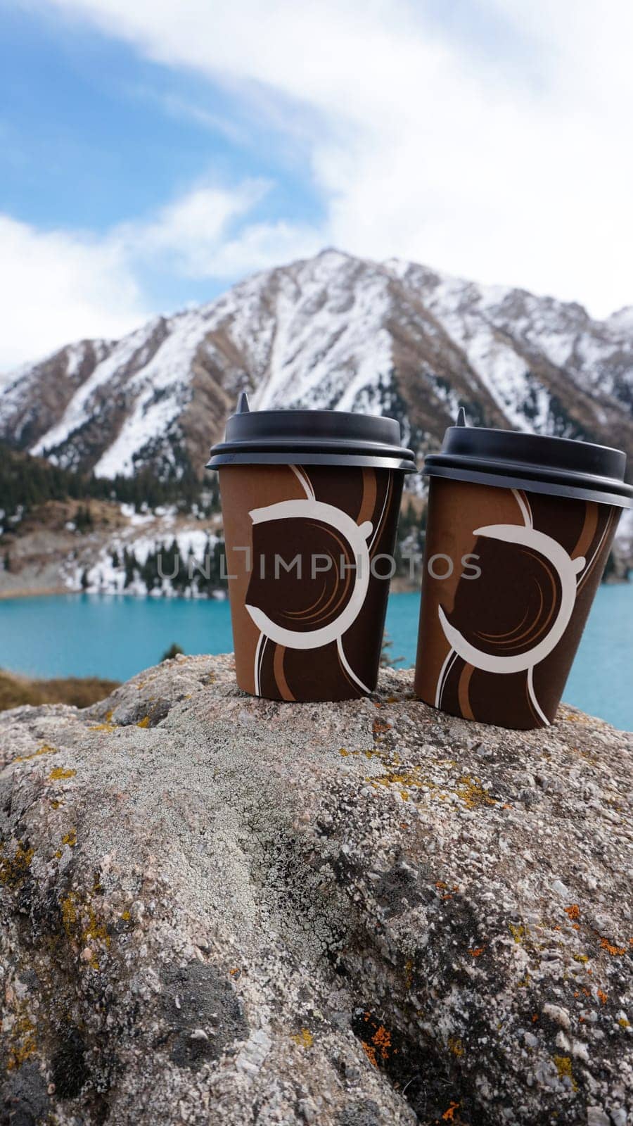 Paper cups on the background of a mountain lake by Passcal