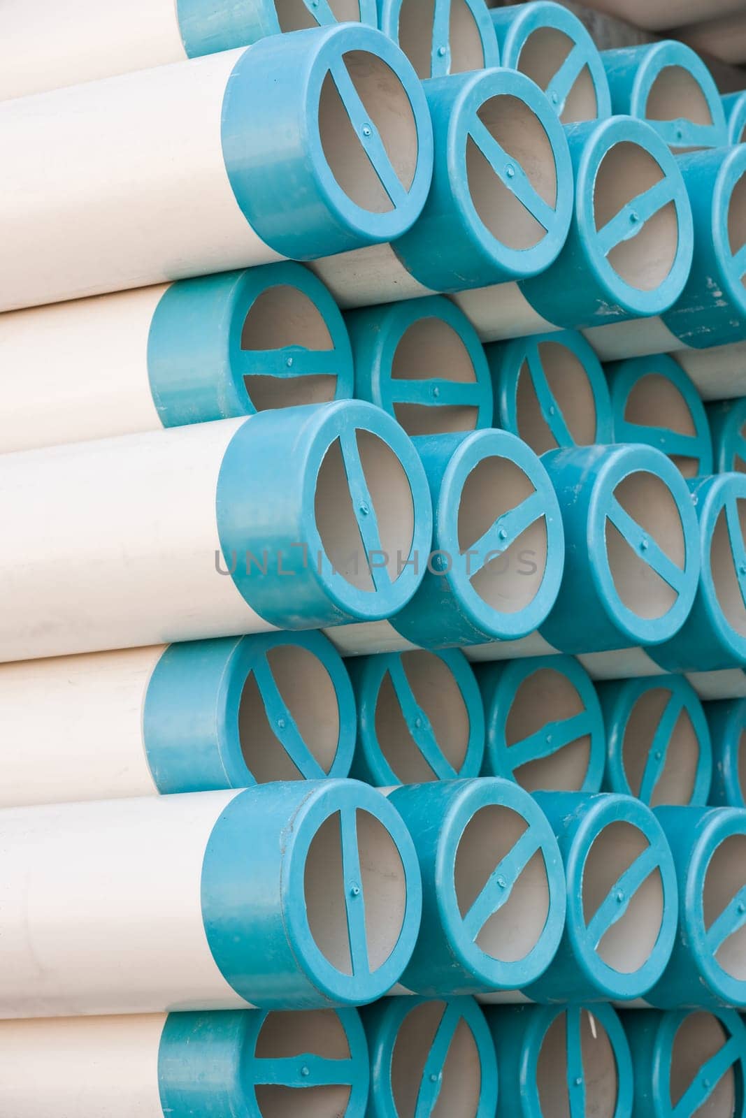 Bunches of PVC pipe sitting on palets at a wholesale pipe store.