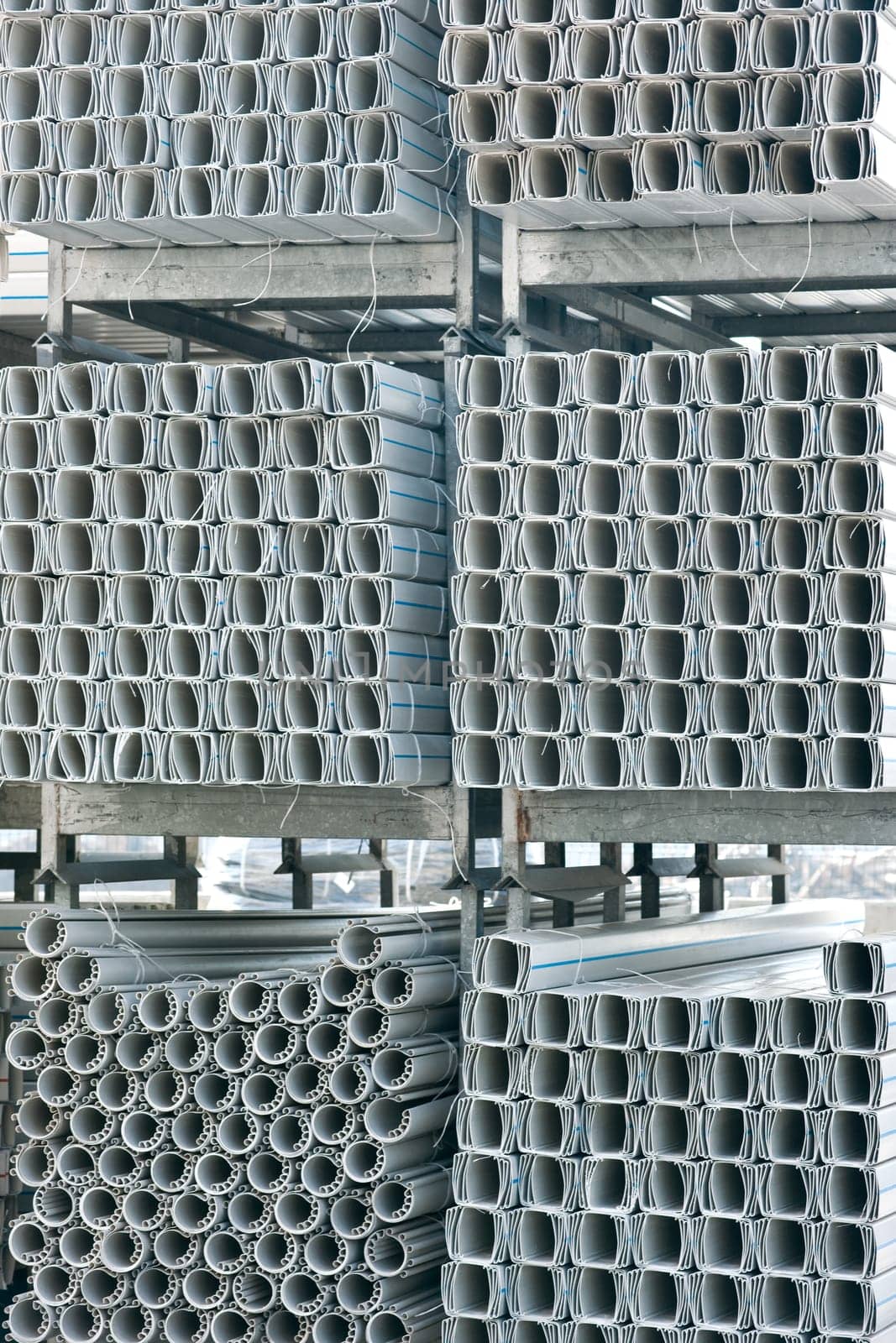 Bunches of PVC pipe sitting on palets at a wholesale pipe store.