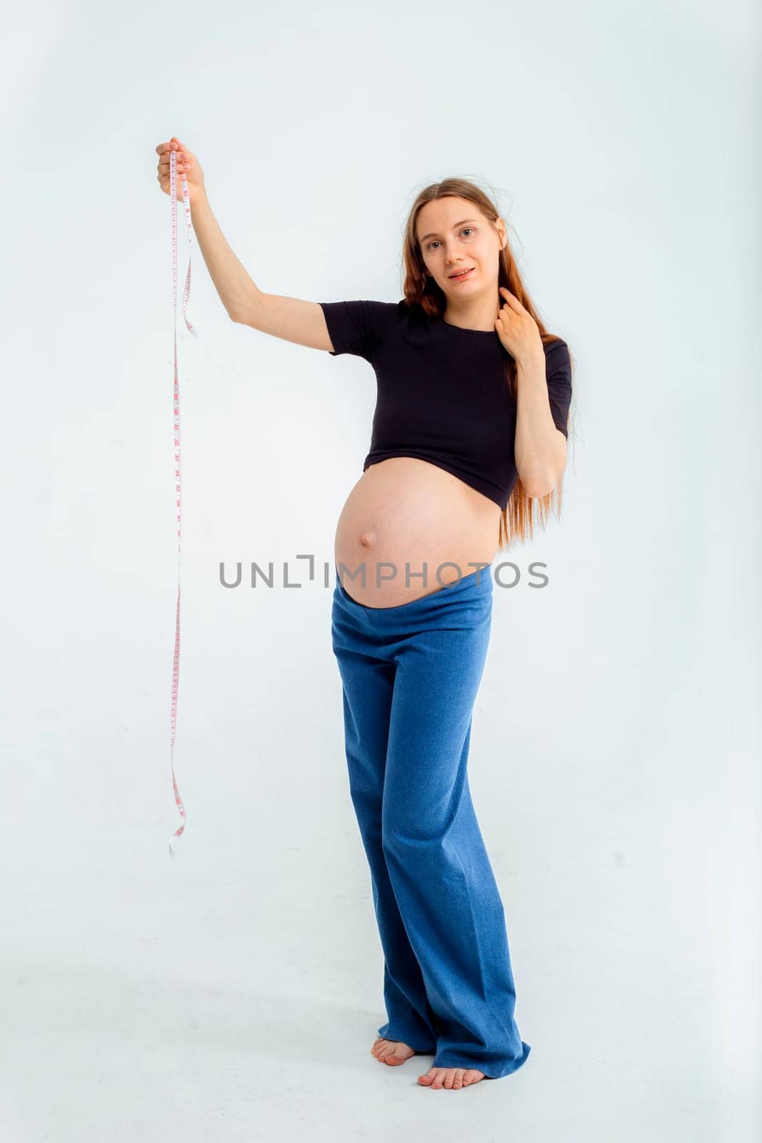Pregnant woman measuring stomach with measuring tape. High quality photo
