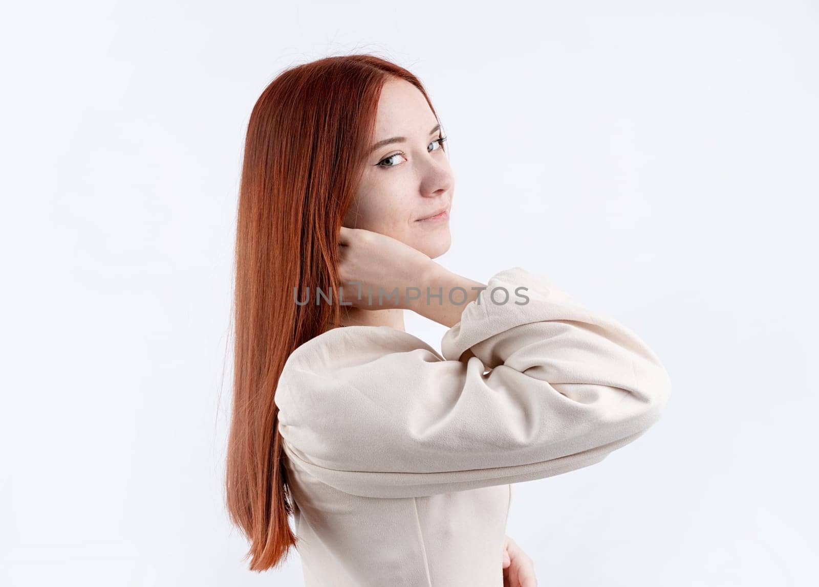 Happy beautiful woman smiling with closed eyes touching her red straight hair over white background, copy space