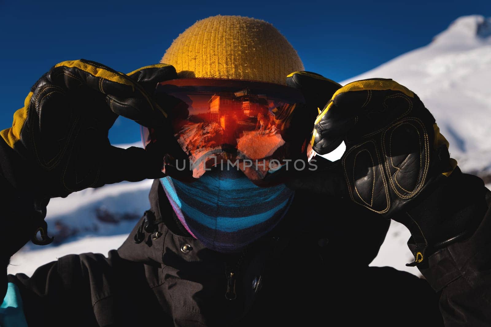 Man in ski goggles. Close-up of a young man in a mask in winter on a ski slope on a sunny day.