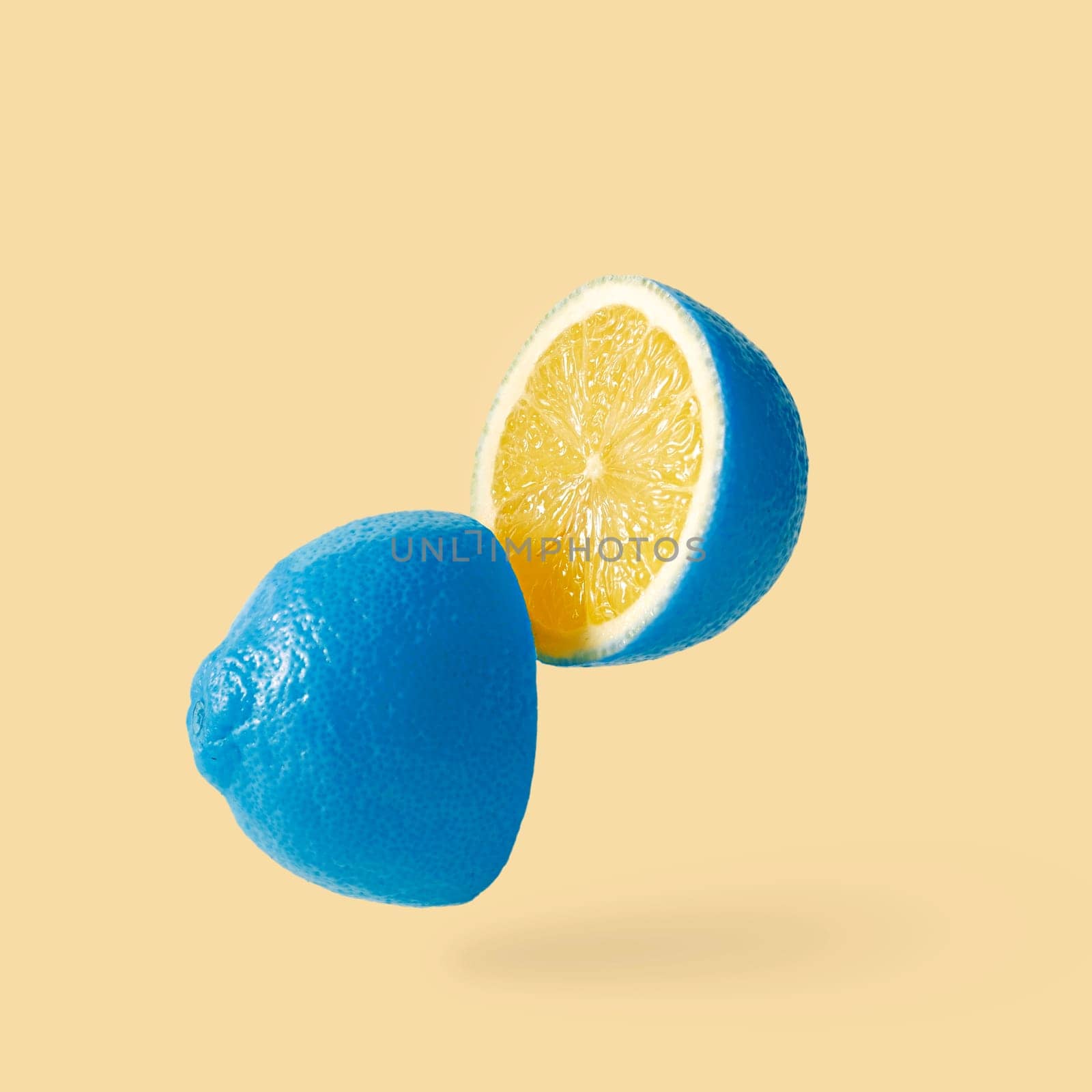 Lemon sureal playful with a blue skin cut into two parts levitation above the background. by sergii_gnatiuk