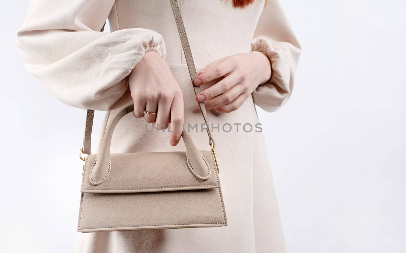 Fashion model woman in autumn outfit with big brown bag scarf. Trendy beige coat