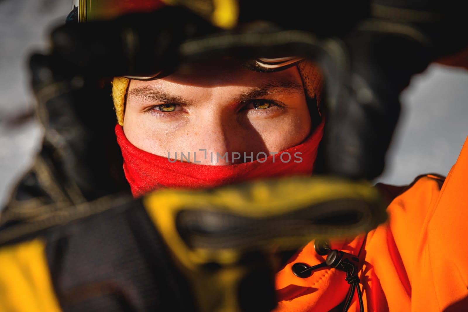 male portrait of a handsome male model with beautiful eyes looking at the camera. athlete dressed in gear outdoors, confident look.