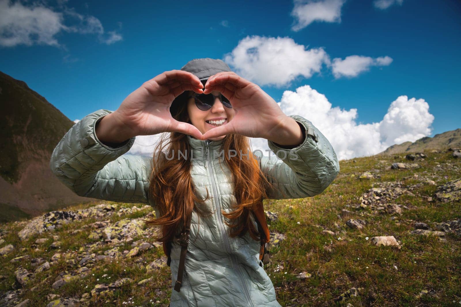 travel and freedom. caucasian woman, happy sportswoman and hiker, showing love sign for hiking in the mountains.