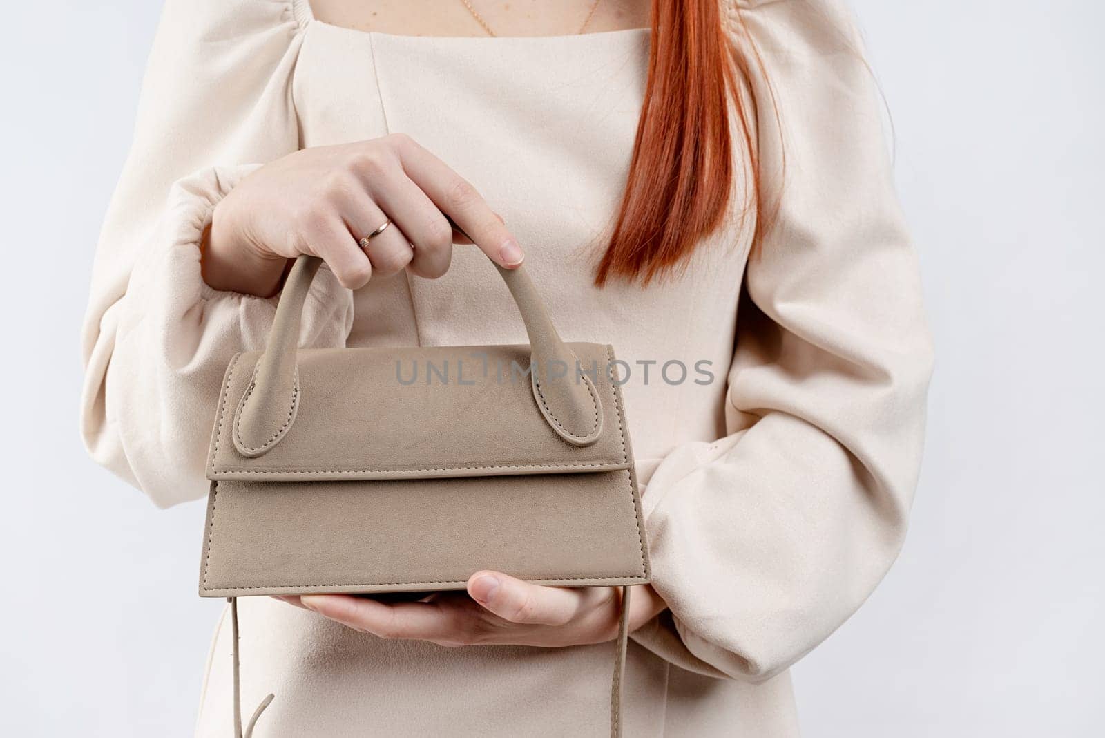 woman in white dress holding trendy fashion bag isolated on white background by Desperada