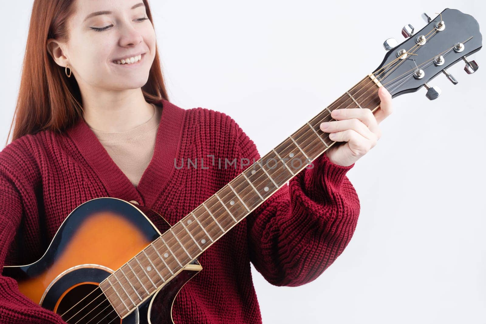 Young woman playing guitar isolated on white background by Desperada