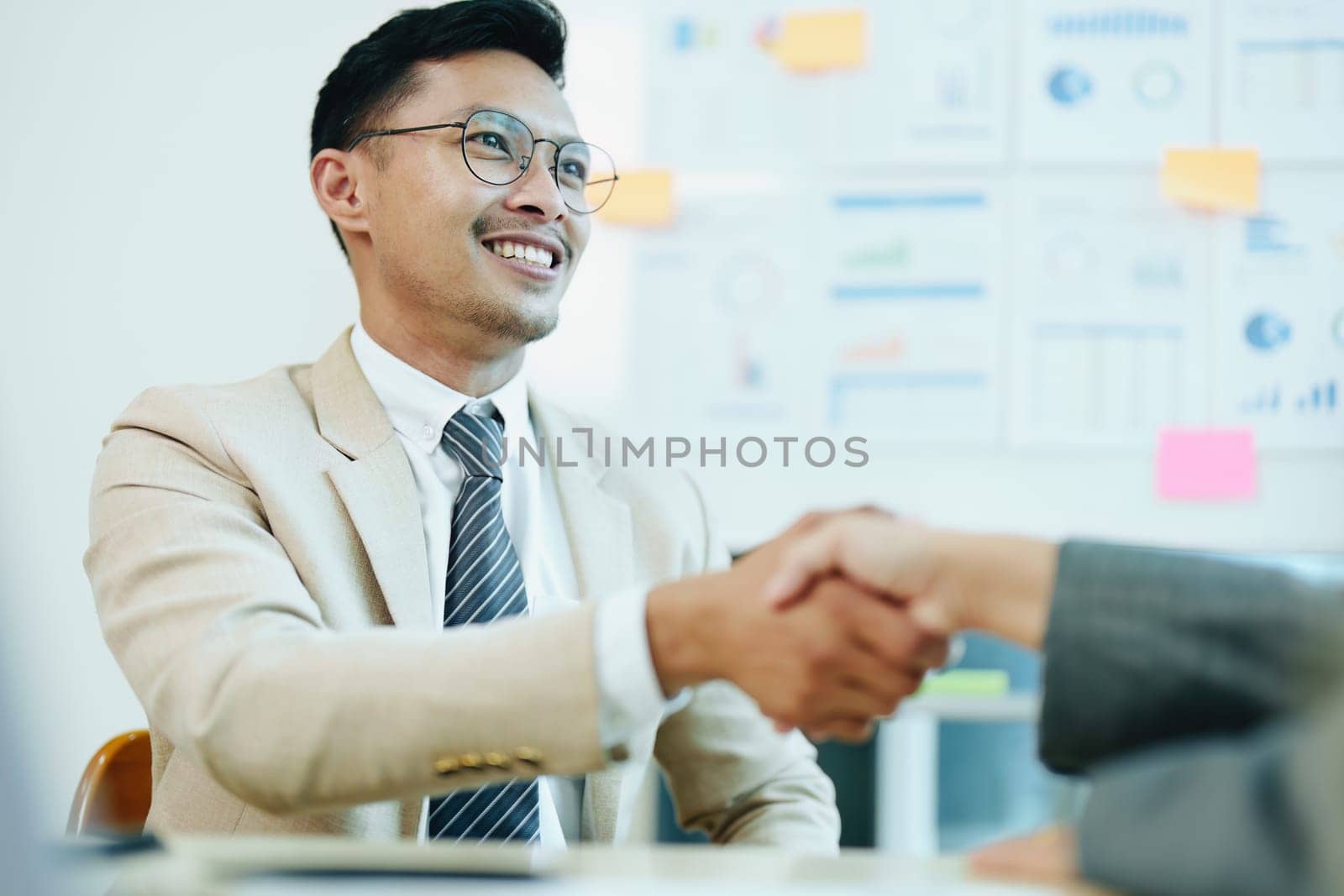 Asian entrepreneurs handshakes to congratulate the agreement between the two companies to enhance investment and financial strength. deal concept.