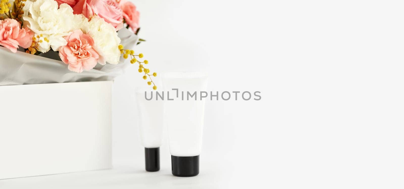 White bottle tube for cosmetic beauty product with natural ingredient and flower. copy space. mockup