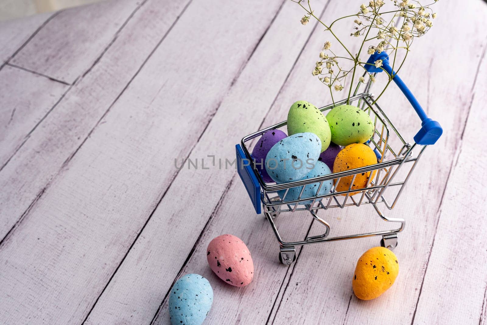 Colorful Easter eggs in a supermarket cart. Easter greeting card. Easter. Quail eggs. Spring holiday concept