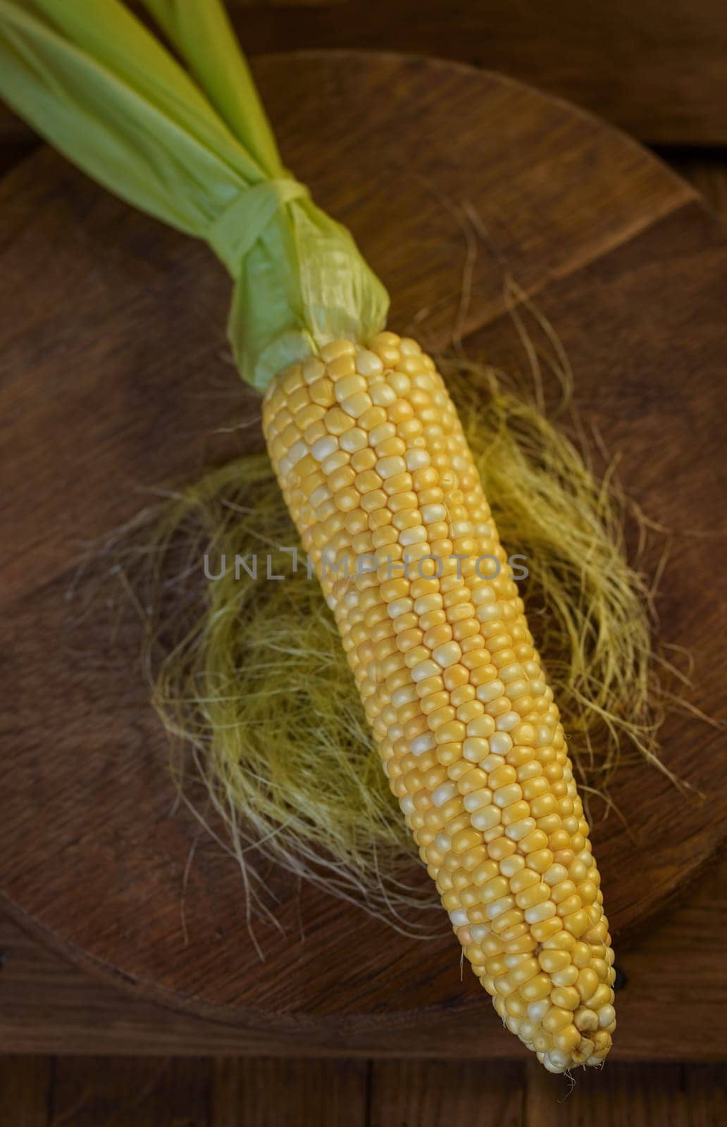 Fresh corn on cobs on rustic wooden table, close up. Sweet corn ears background by aprilphoto
