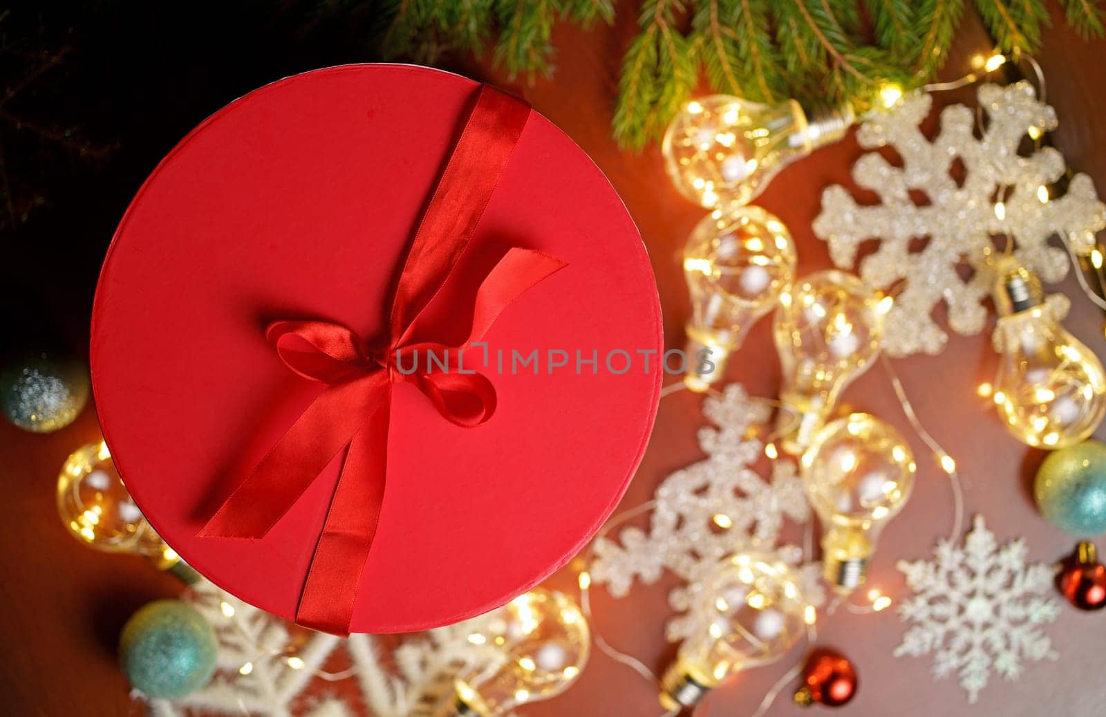 Woman holding christmas gifts laid on wooden table background with christmas decoration