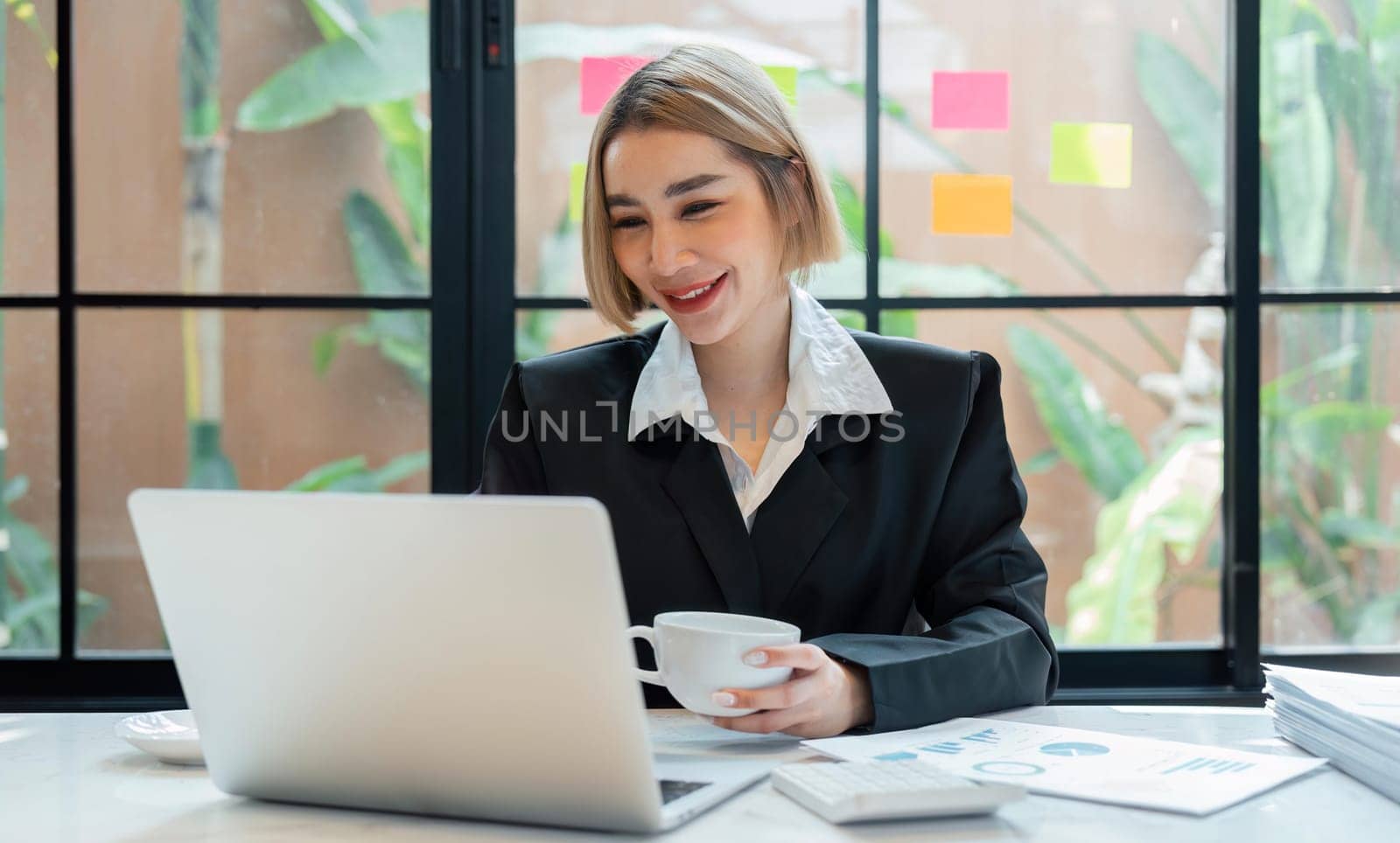 Asian business woman accountant working audit and calculating expense financial summary report balance sheet statement and doing finance making notes on paper for checking document by nateemee