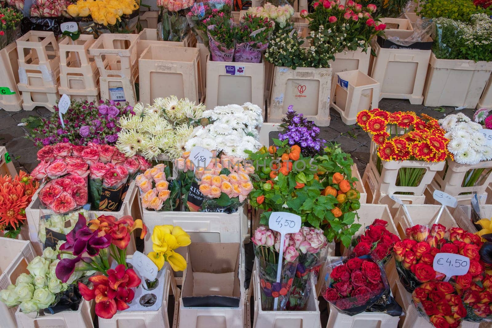 different flowers are sold in the market in baskets, with price tags, High quality photo