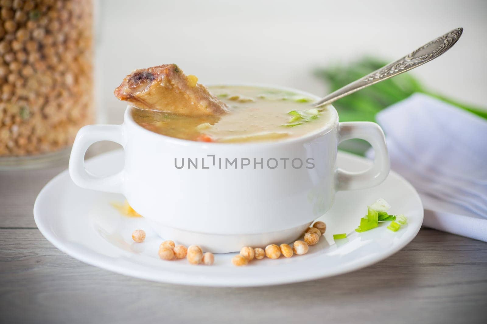 dried pea soup in a plate with herbs, on a wooden table.