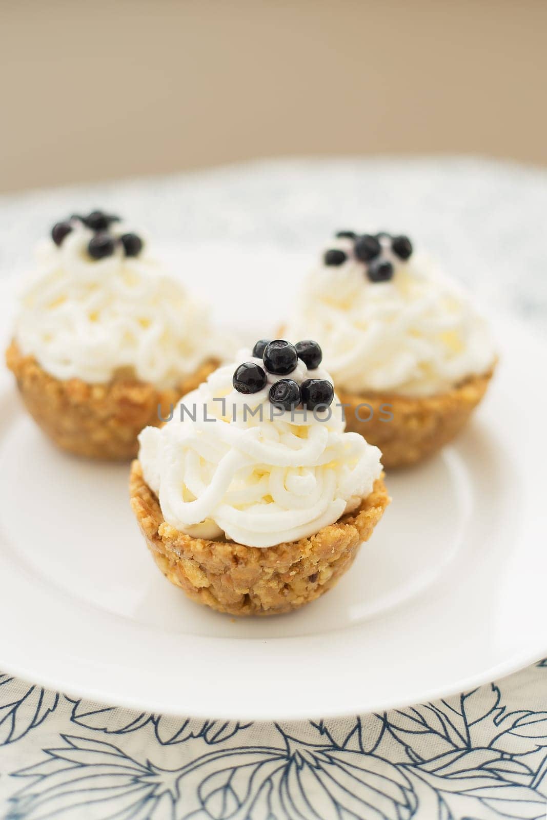 Homemade muffins with blueberries, cream and fresh berries on a napkin by sfinks