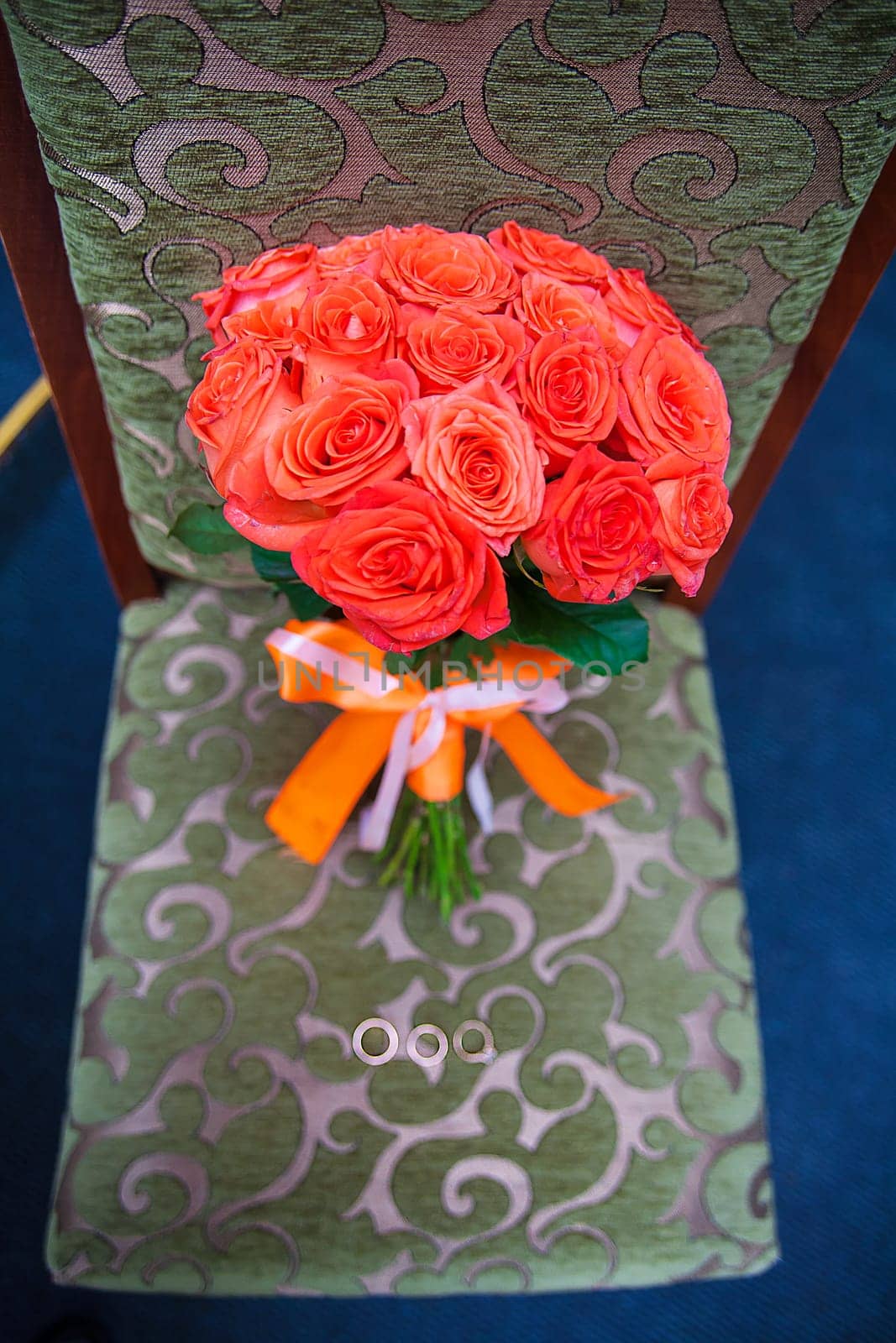 wedding bouquet with red flowers on a chair with a ring.