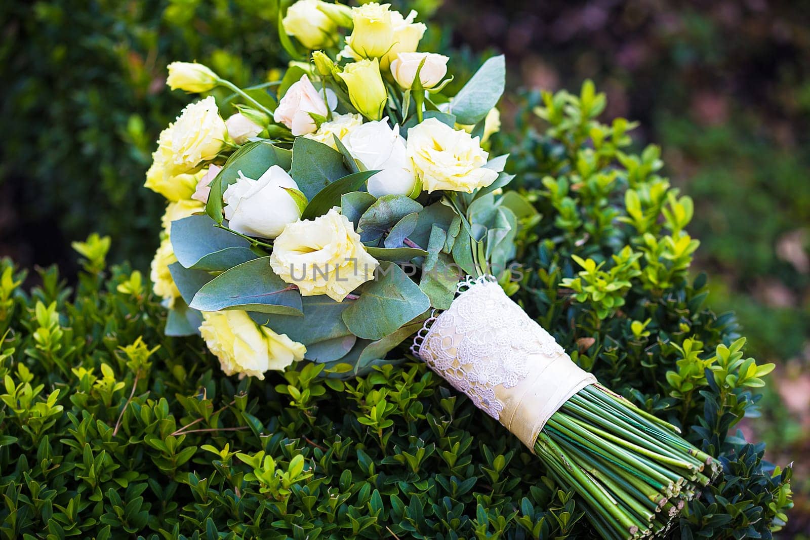 beautiful bridal bouquet lying on green grass by sfinks