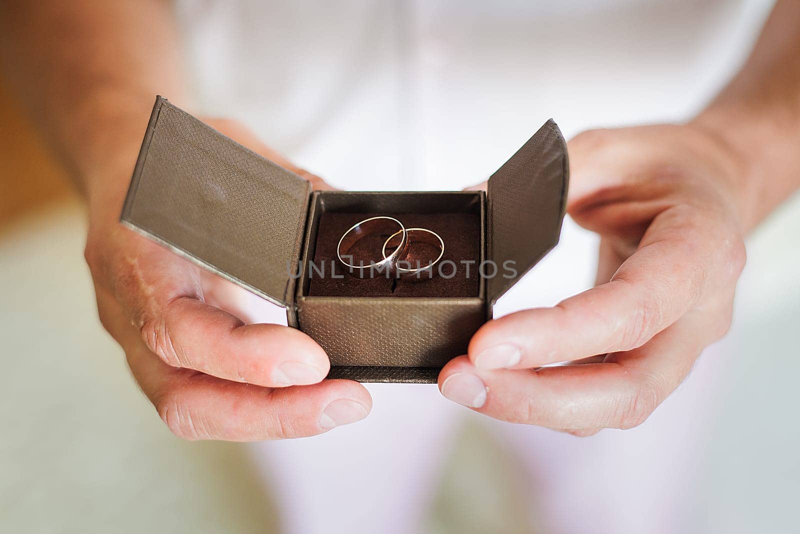 groom holding a beautiful box with wedding rings