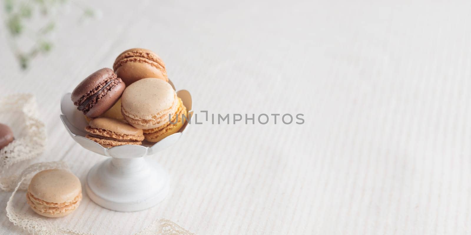 Chocolate, vanilla, coffee eco handmade natural macaroons in a vase on white table. Gift for 8 March, International Women's Day, Valentine Day. Horizontal banner closeup with a copyspace