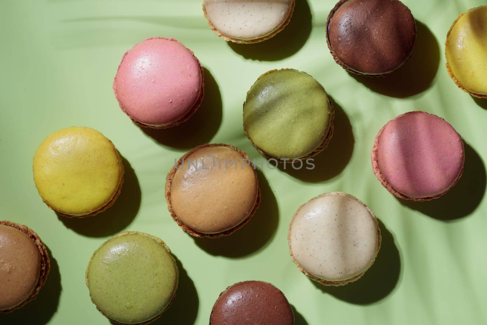 Colorful pastel eco handmade macaroons on green background with a shadow. Gift for 8 March, International Women's Day, Valentine Day. Horizontal banner