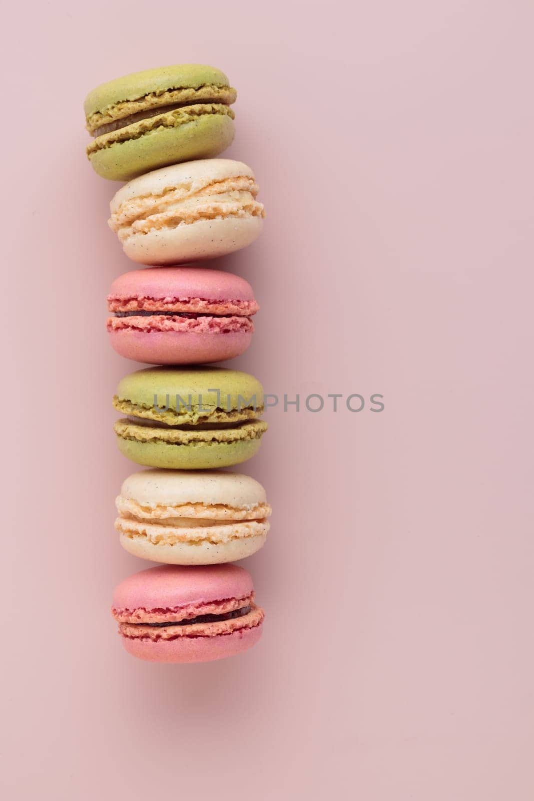 Macaroons on pink background, colorful french cookies pattern. Gift for 8 March, International Women's Day, Valentine Day. Vertical banner with copyspace