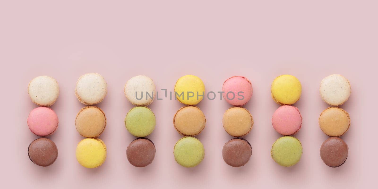 Macaroons on pink background, colorful french cookies pattern. Gift for 8 March, International Women's Day, Valentine Day. Horizontal banner with copyspace