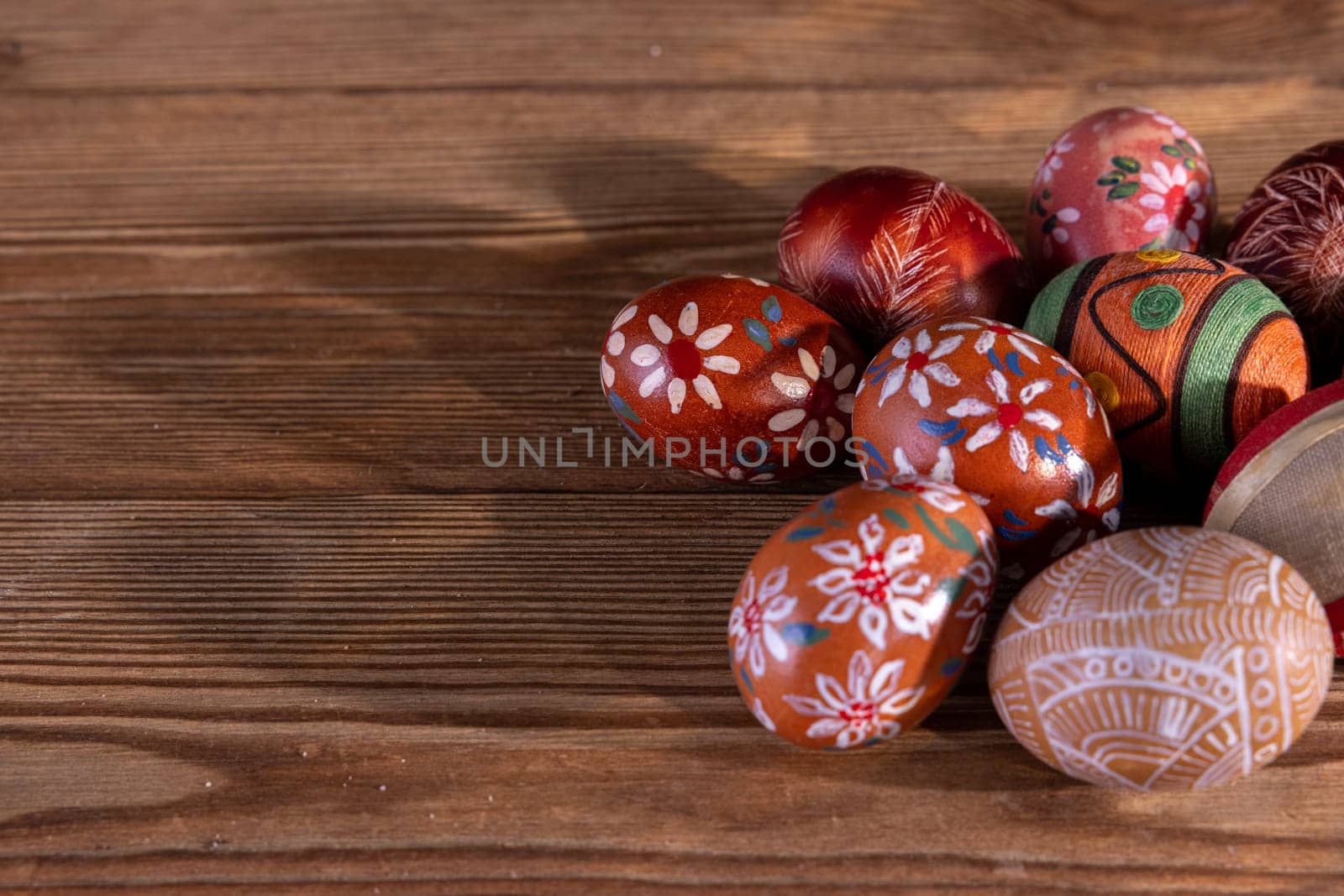 Easter composition of several Easter eggs with brown tones arranged on old brown boards. Blank bowl for adding inscriptions.