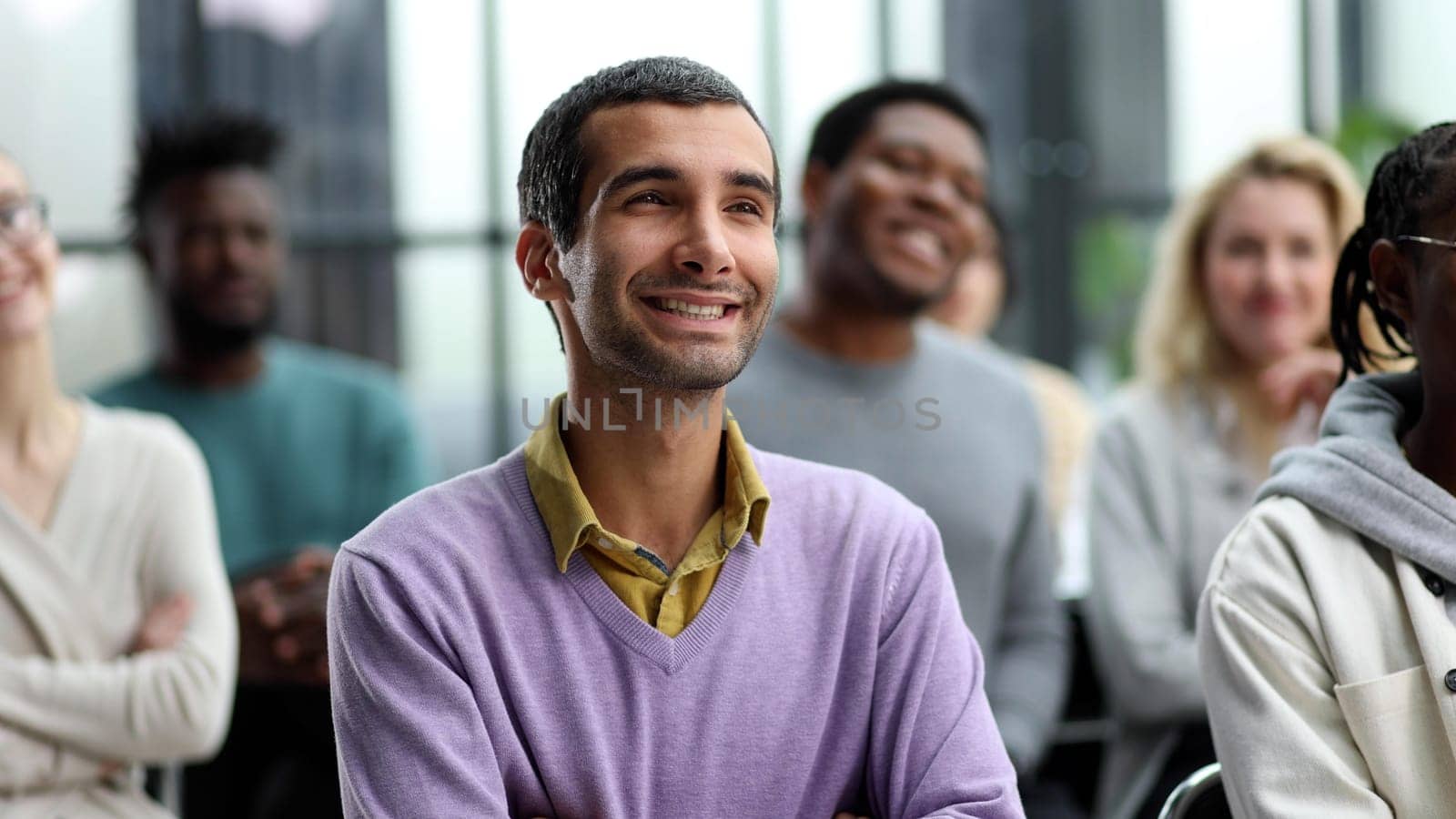 Group of happy interested business people listening to a colleague during a meeting