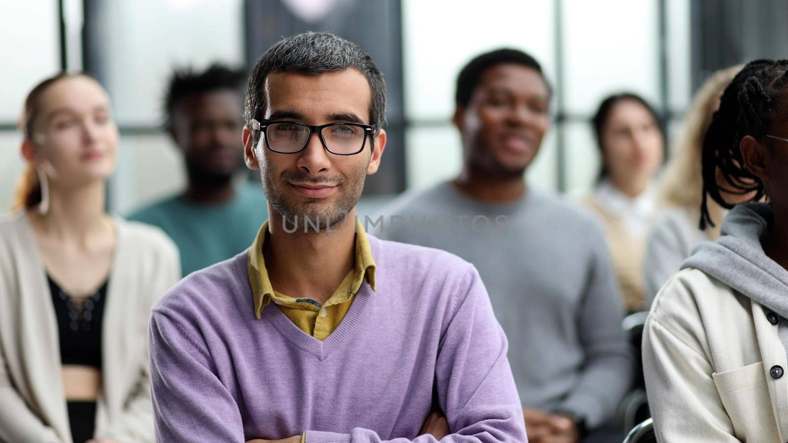 Business trainer. A man gesturing with his hand while standing in front of a group of people by Prosto