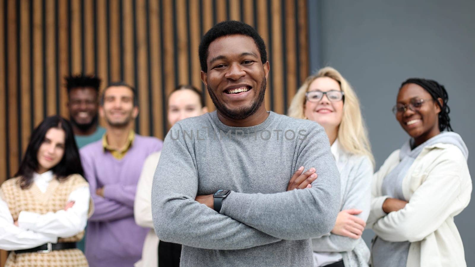 Portrait of a young businessman at the office standing in front of his colleagues